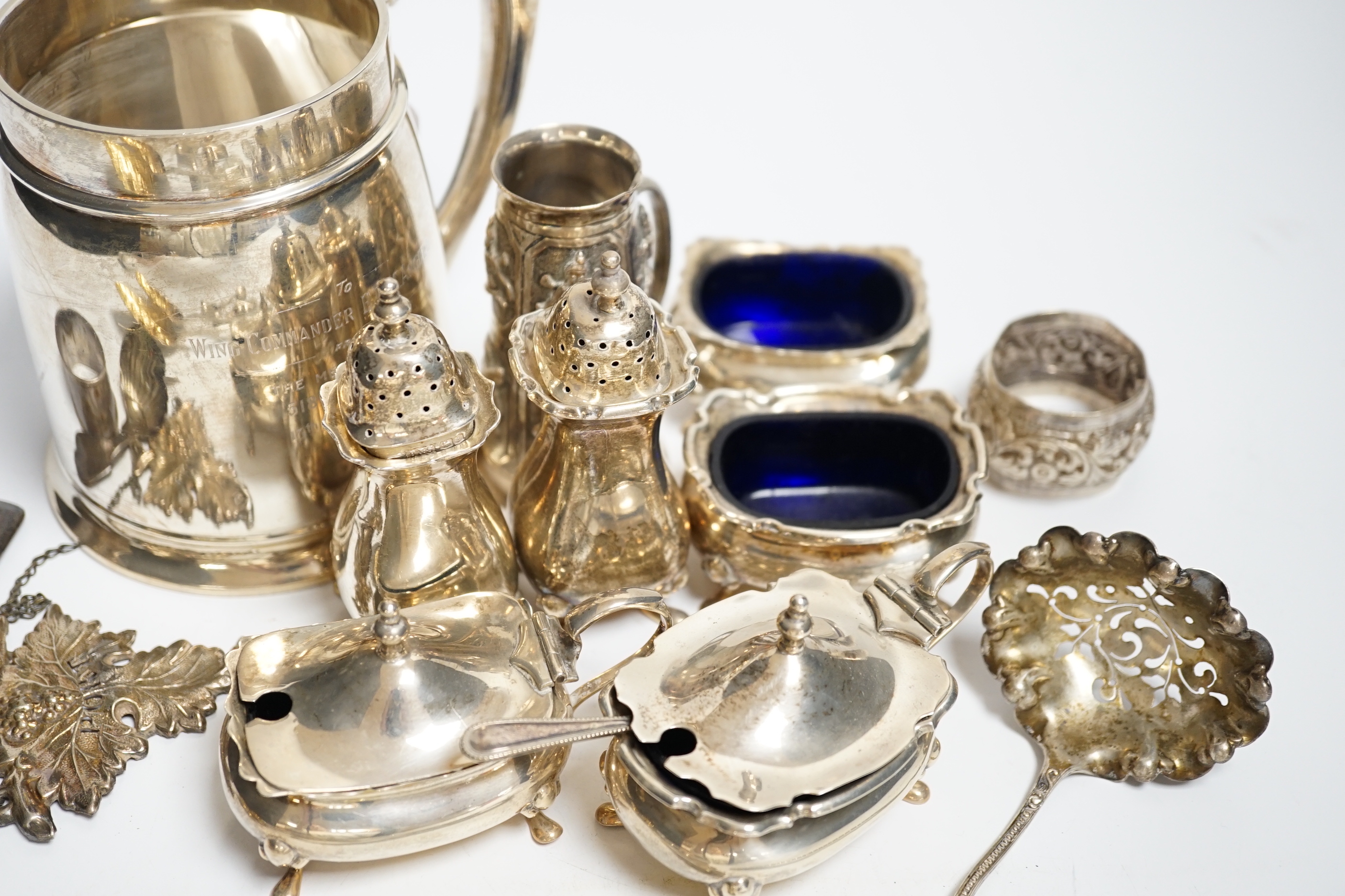 A George VI silver mug, Birmingham, 1937, 11.5cm with engraved inscription to Wing Commander E.E.M Angell, a pair of George III Old English pattern berry spoons, a George IV silver caddy spoons and other items including